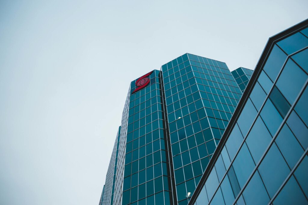 Low angle view of a contemporary glass skyscraper with a clear sky backdrop.